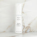 Hair spray bottle on a marble surface