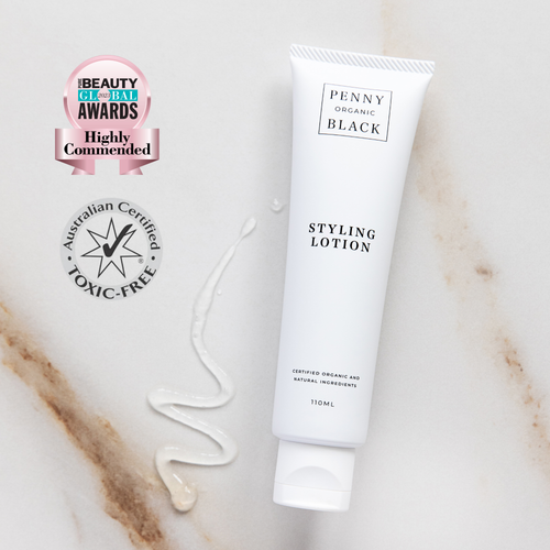 Penny Organic Black styling lotion tube on a marble surface with awards badge.